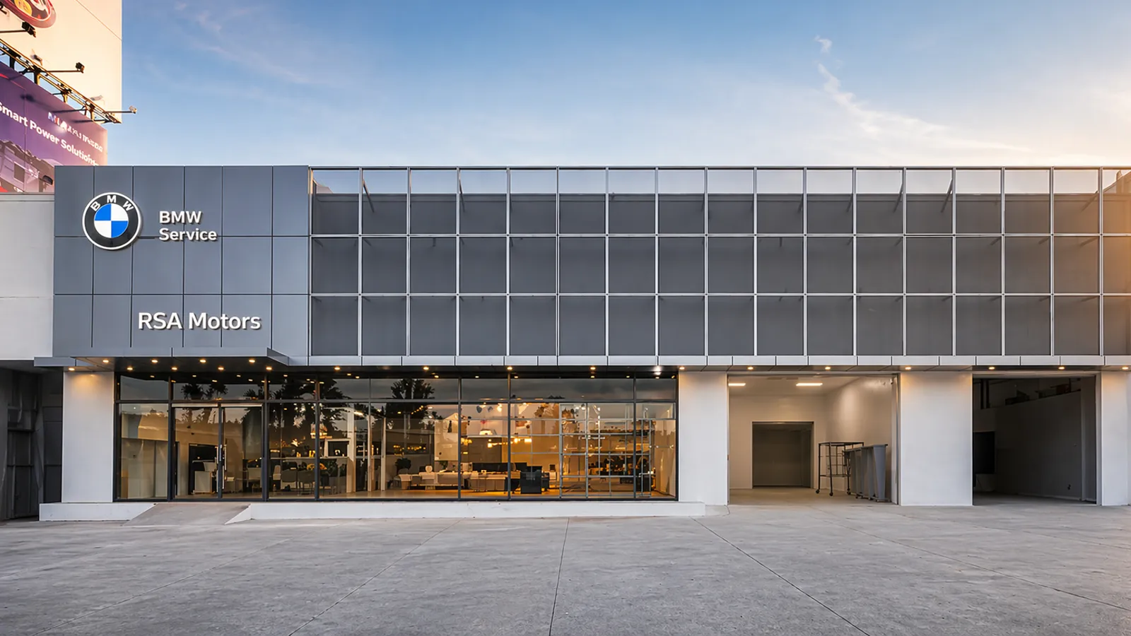 BMW flagship service center for RSA Motors: glass and steel facade at dusk